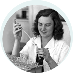 A woman in a lab coat filling a test tube